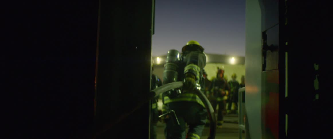 Firefighters work on the scene of accident at dusk