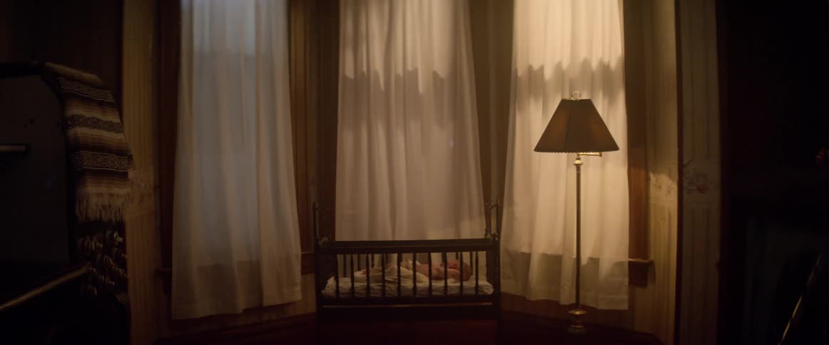 A baby lays in a crib
