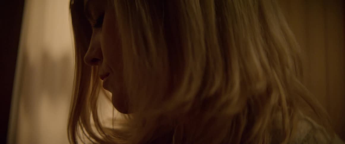 A woman is rocking back and forth in the dark room