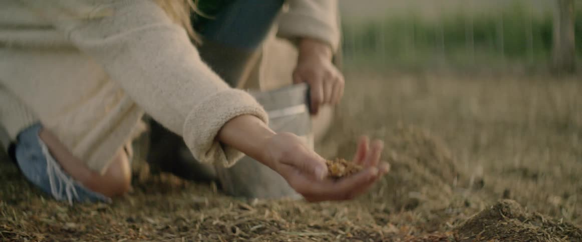 A woman is checking soil on the ground