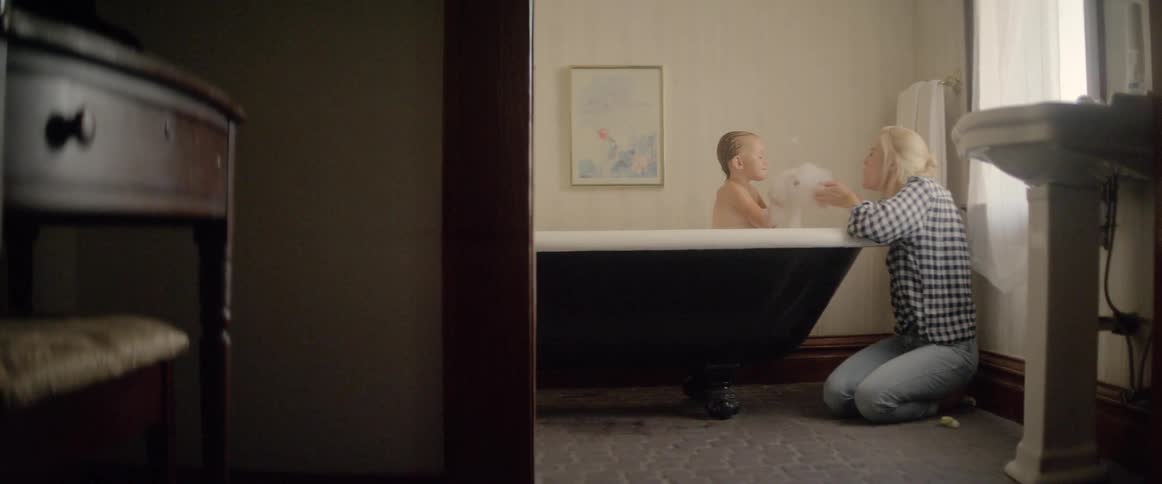 The mother washes her child in the tub
