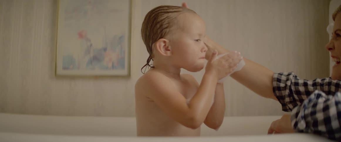 A mother gives her daughter a bath