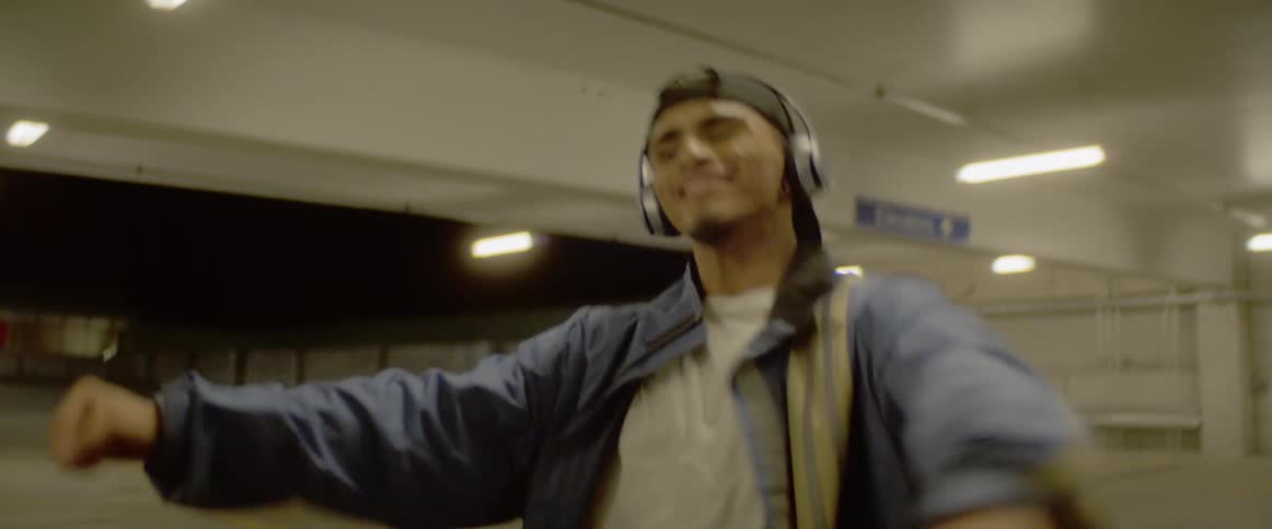 A man dances in a parking garage