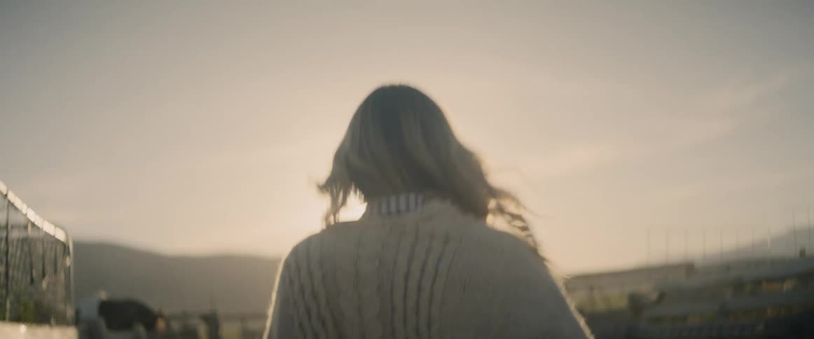 A woman walks past a horse on a windy day