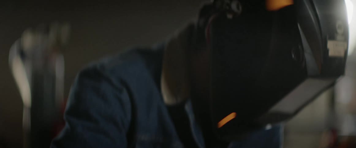 A person uses a grinder in the shop