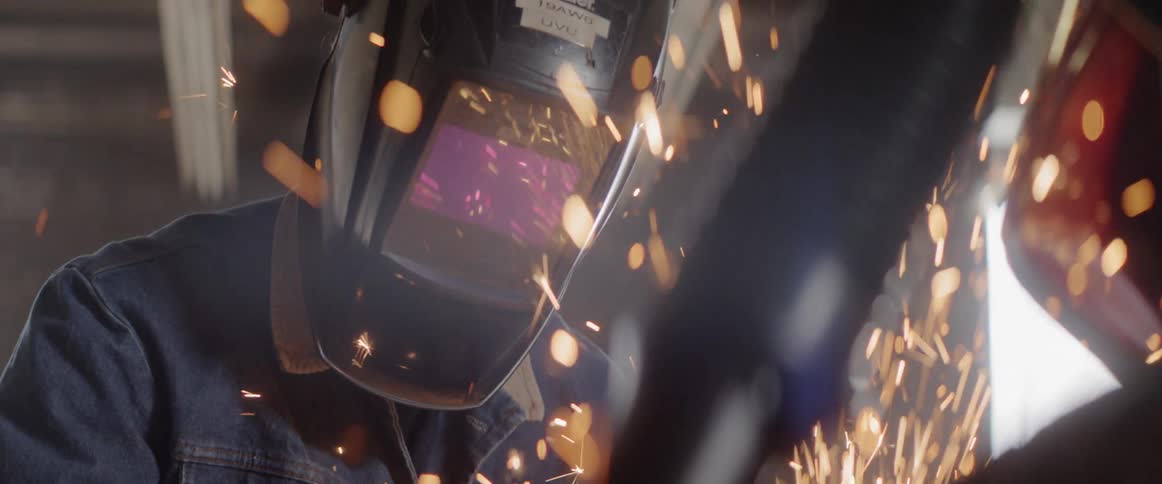 A welder is working in his shop
