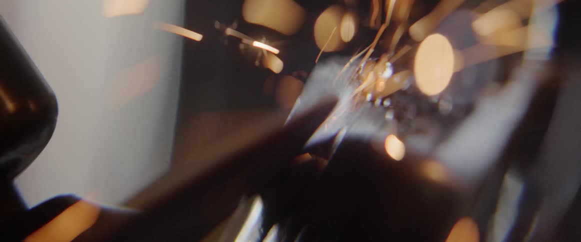 Spinning disk grinds against metal casting sparks into the air