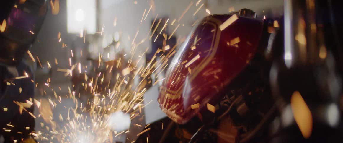 Sparks fly as a welder uses a tool to grind metal