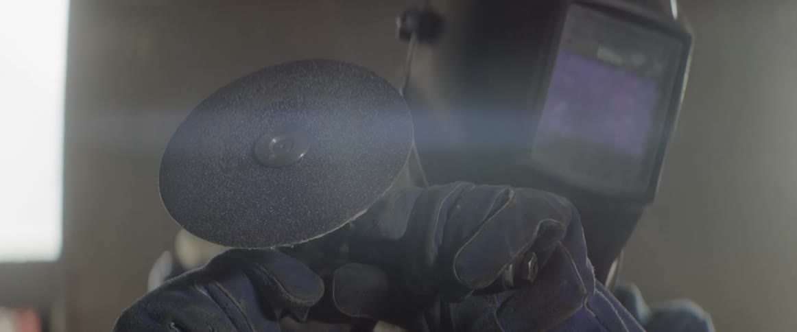 A man in a helmet holds a tool