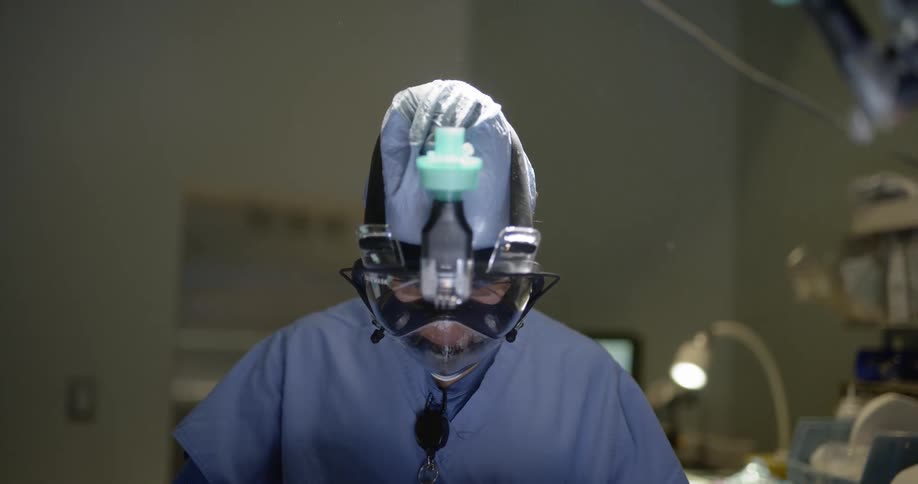A surgeon is doing a procedure in a hospital