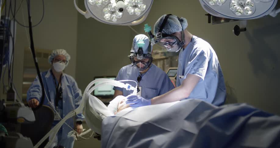 Medical personnel work on a patient on an operating table