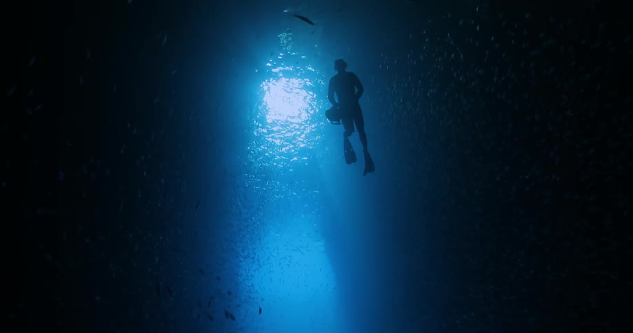 Diver swimming in the ocean with an underwater camera
