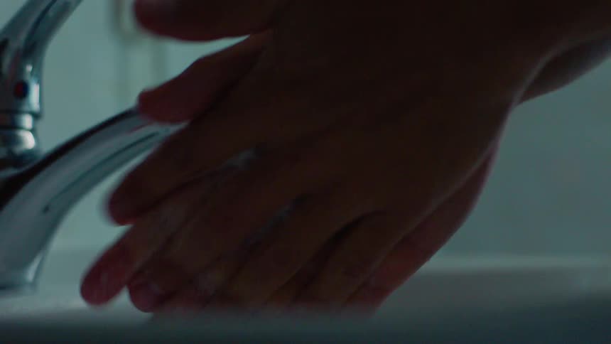 A man washes his hands in the sink