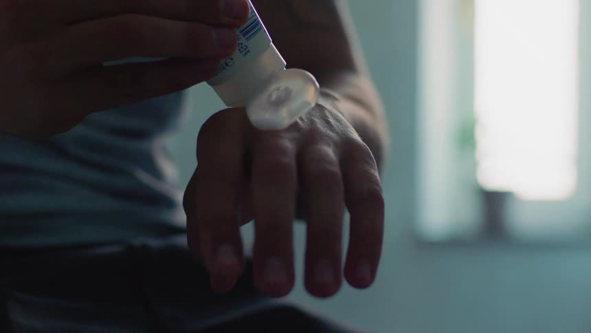 A man puts cream on his hand