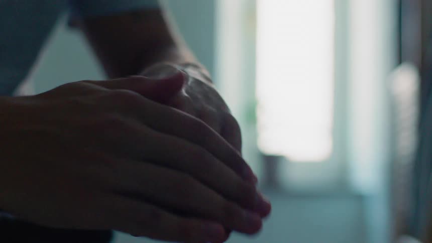 Man applies cream on his hand in the bathroom