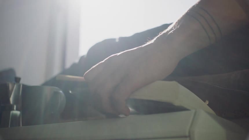 Man sitting next to the window drinks a cup of coffee and reads a book