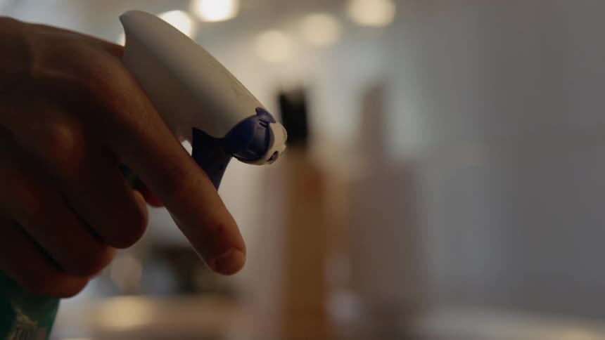 A person cleans up spraying a spray bottle