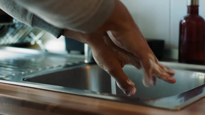 A man is washing his hands with soap