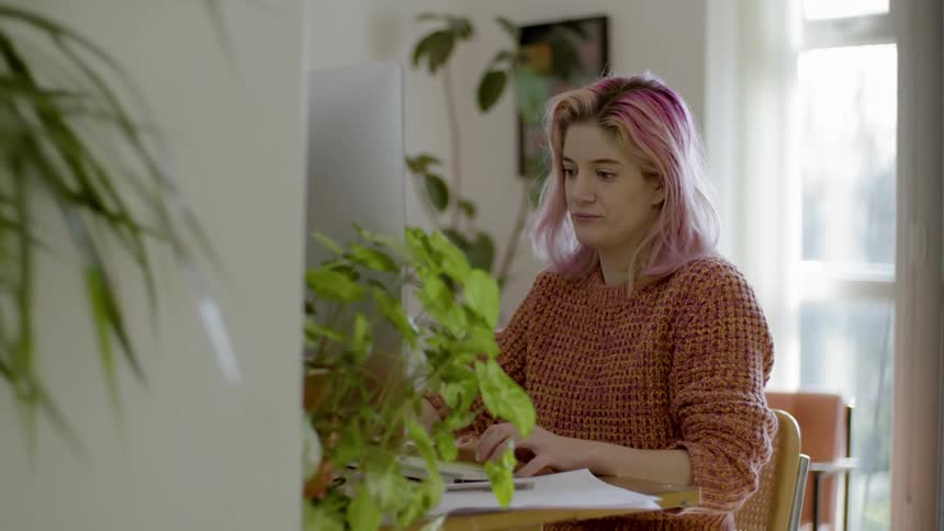 A woman sitting at a desk typing on a computer