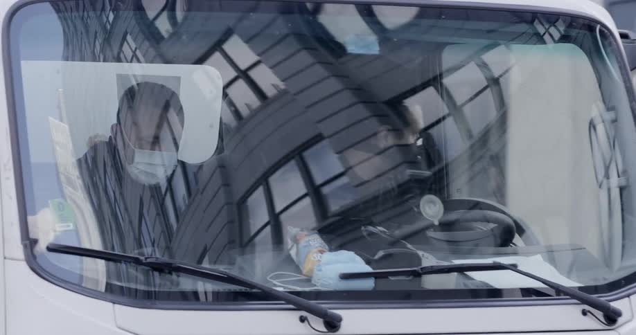 Two people drive a truck wearing masks