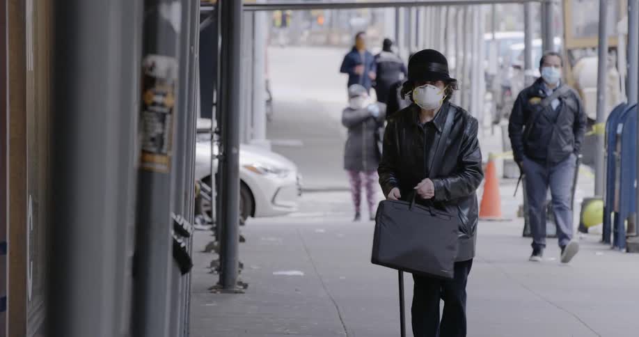 People walking down a city street with masks on