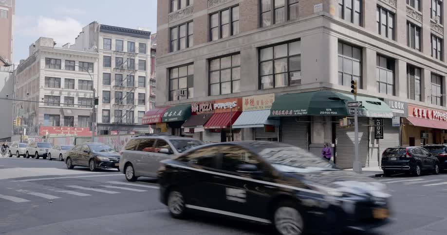 Woman stops at the edge of the street and checks for cars to cross the street in the city