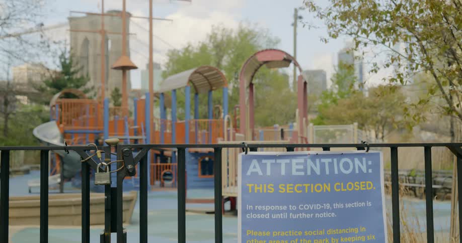 A sign hangs on a locked up playground