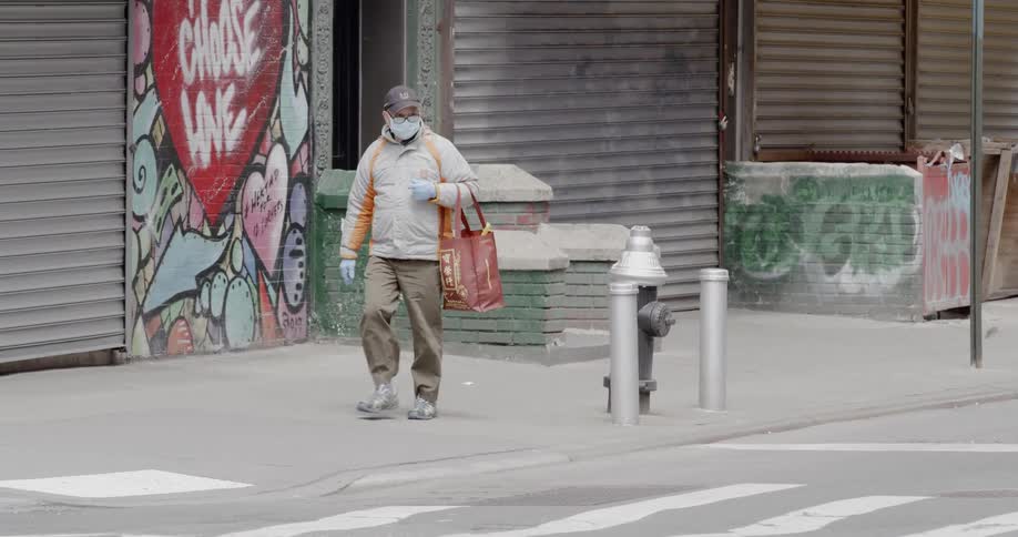 A man carries a bag as he walks down the street