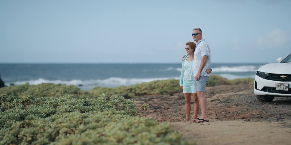 Couple hugging and watching the ocean near the cliff side
