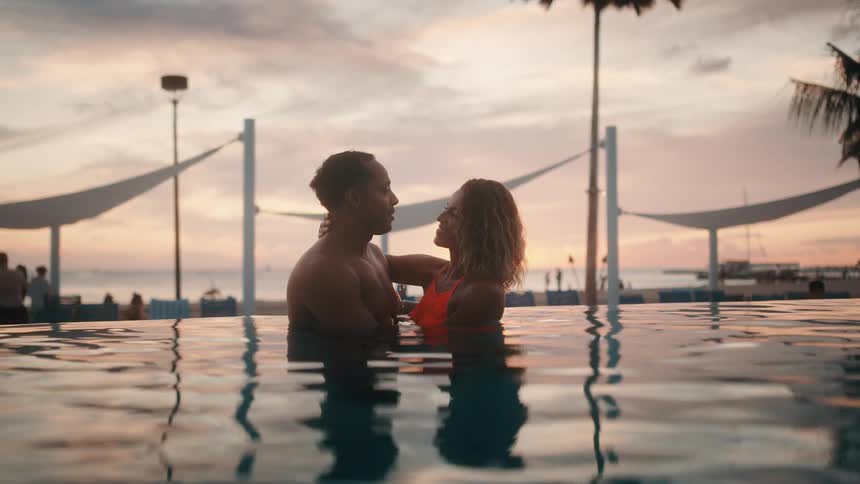 A man and woman hug in a swimming pool