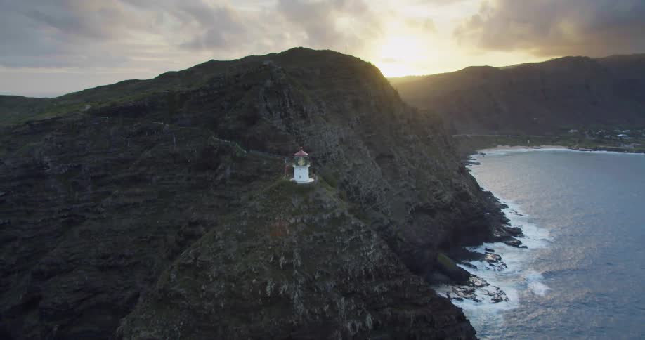 A light house sits on a cliff above the shoreline