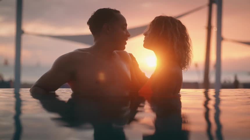 Couple standing in water at beach talking