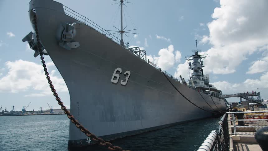 Naval vessel rests at dock during the day