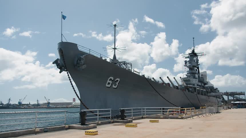 A large naval ship is docked