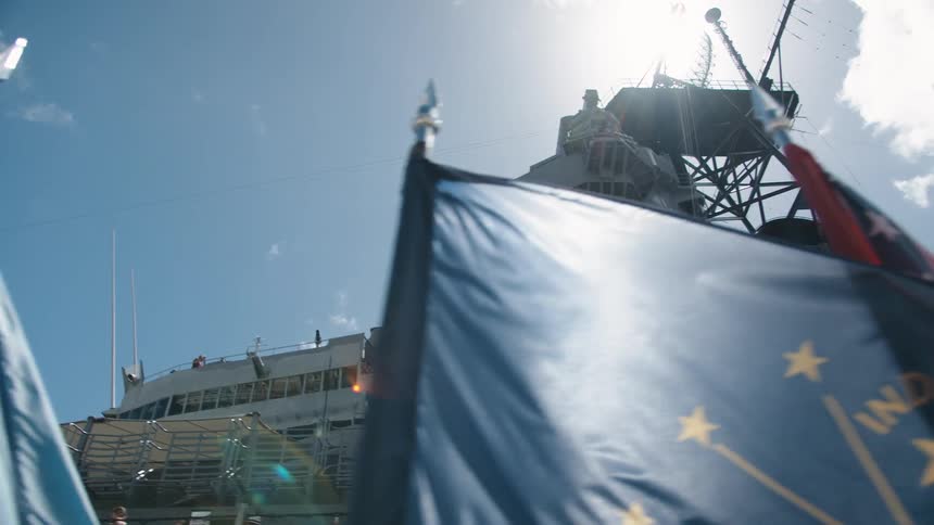 Flags fly in front of navy aircraft carrier