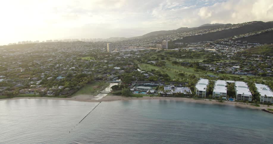 Neighborhoods and tall buildings sit along the shore next to the ocean