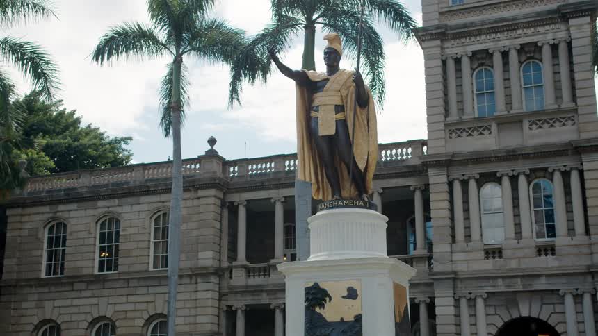 A statue in front of a large building