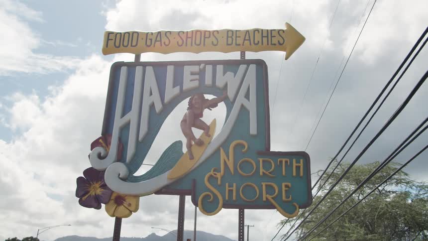 Billboard sign advertises the beach under a cloudy sky