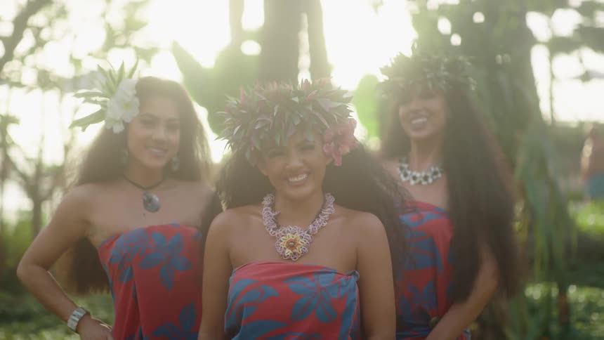 Three young hawaiian women posing for camera and smiling