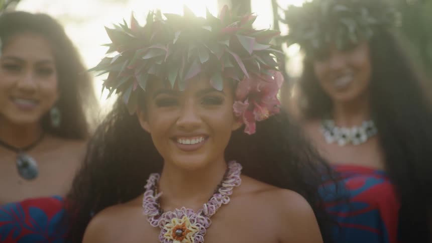 Hawaiian girls smile at the camera at sunset