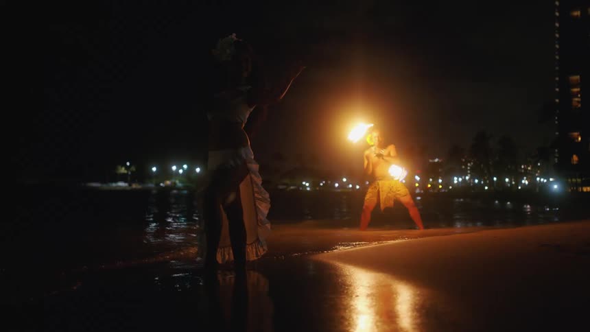 Traditional hawaiian fire dancer on the beach at night