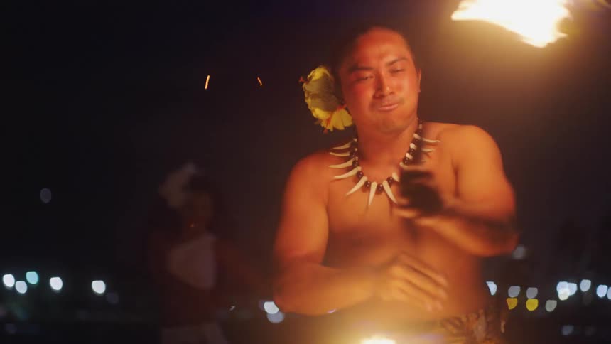Hawaiian fire dancer performs at night