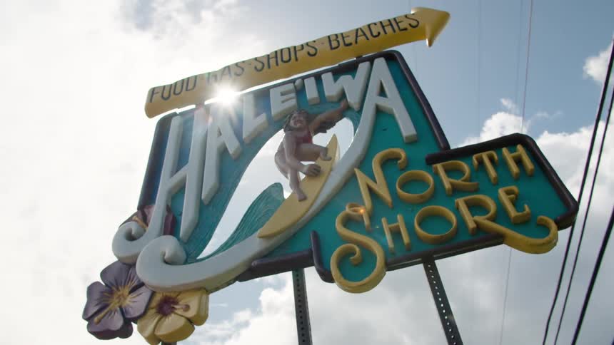 The sun shines behind a sign