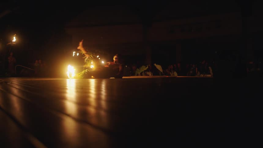 A man dances with fire in front of a an audience