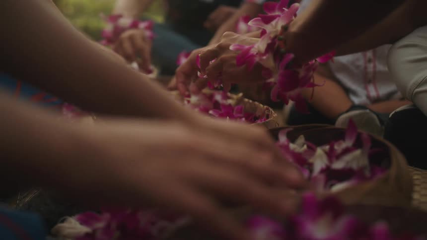 A group of people sitting around and reaching into baskets of flowers