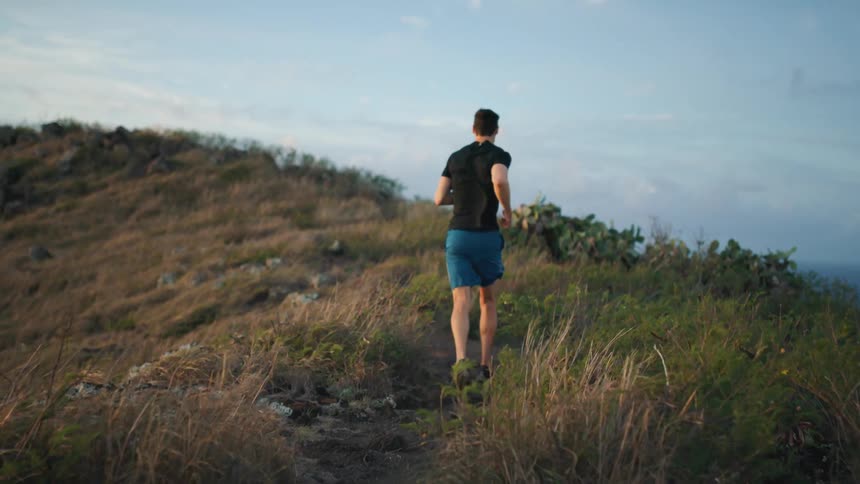 A man jogs up the hill on a windy day