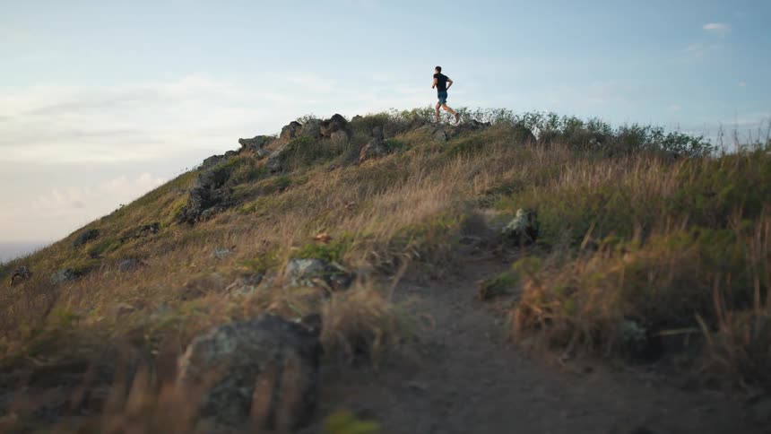 A young man runs up a hill