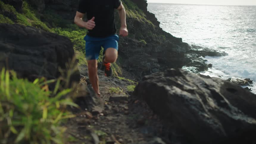 A man runs uphill near the shore