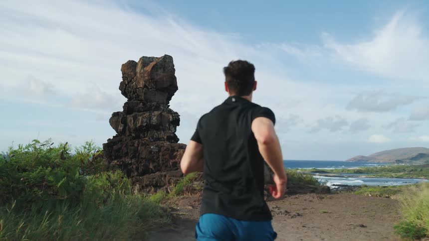 A man runs along a path towards the water
