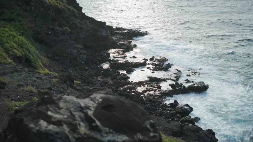 The waves crash against the shore below